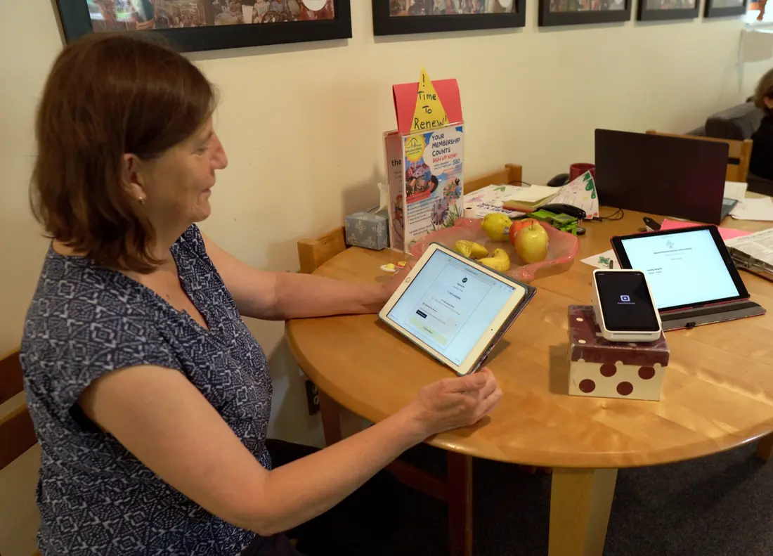 A staff member greeting and talking with a parent at the centre